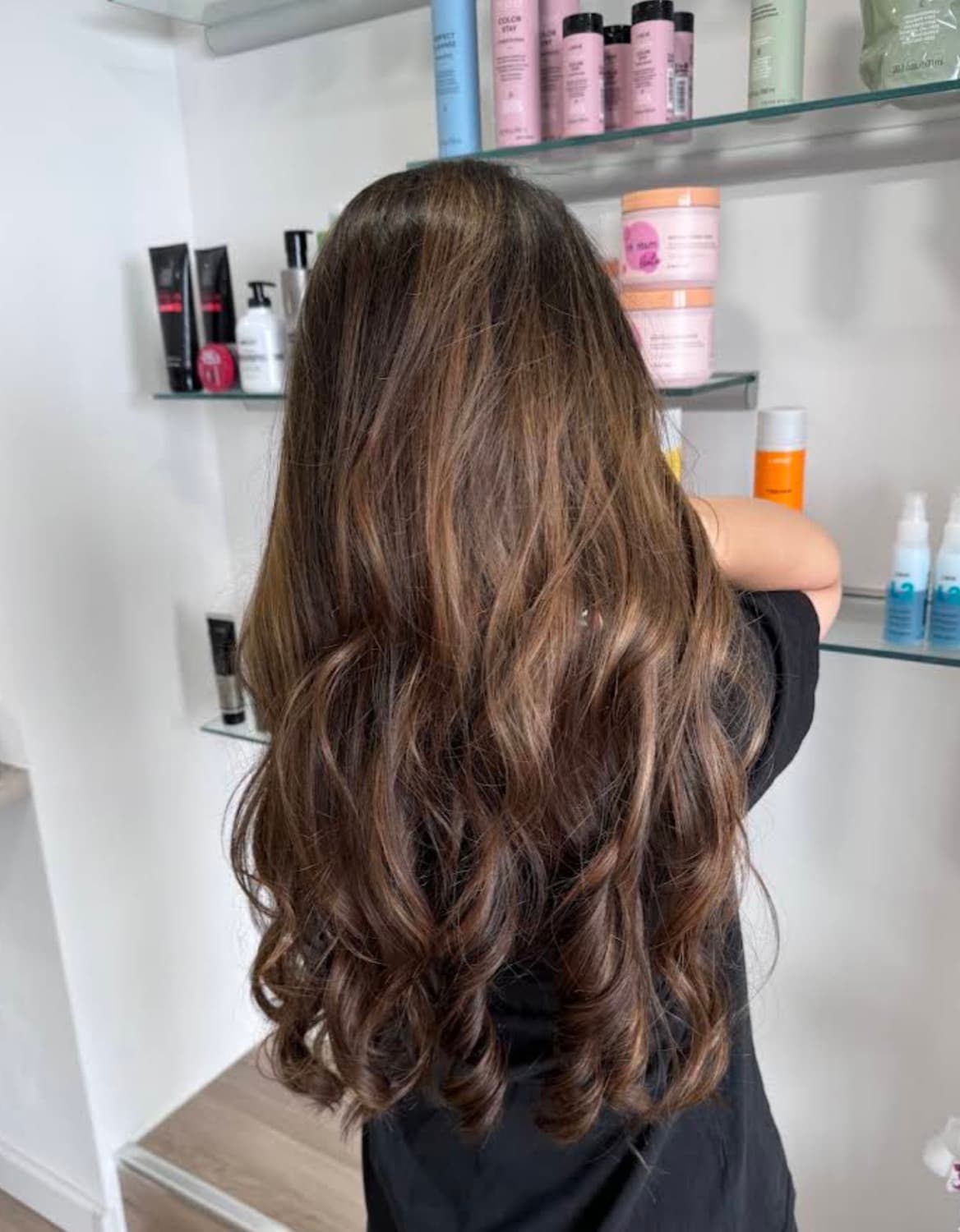 Balayage brun lumineux et ondulations souples réalisés à Genève